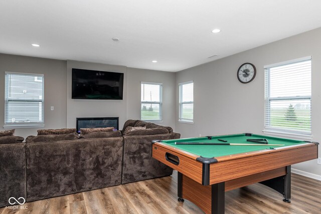 game room featuring recessed lighting, wood finished floors, pool table, a glass covered fireplace, and baseboards