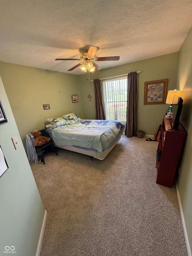 carpeted bedroom with baseboards, a ceiling fan, and a textured ceiling
