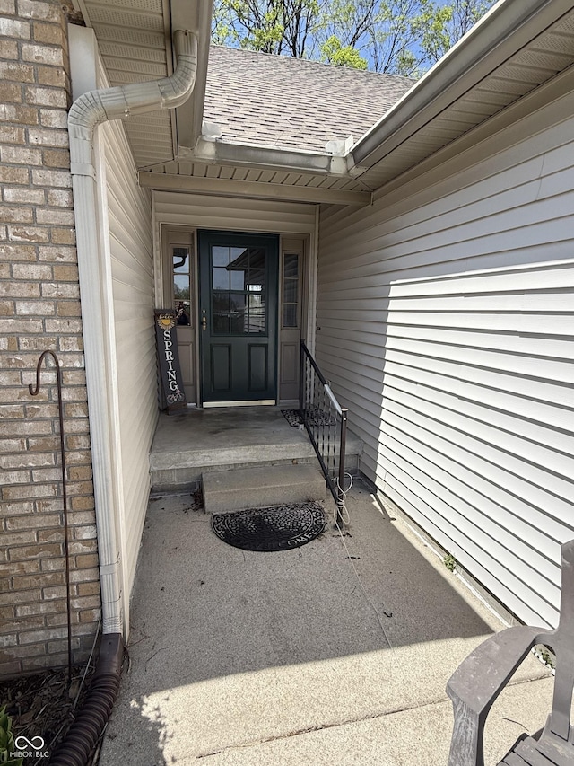 property entrance with a shingled roof