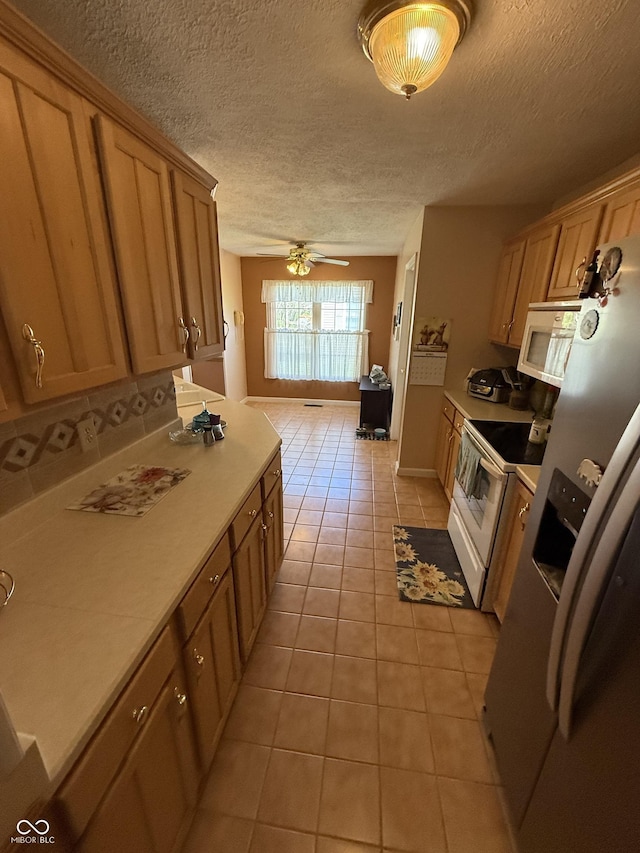 kitchen featuring ceiling fan, white appliances, a textured ceiling, and light tile patterned floors