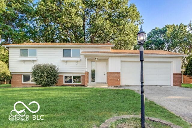 7206 Halden Pl, Indianapolis, IN 46214 - view of front of house featuring brick siding, asphalt driveway, a garage, and a front yard