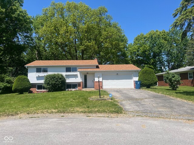 7206 Halden Pl, Indianapolis, IN 46214 - view of front of home featuring a garage, asphalt driveway, brick siding, and a front lawn