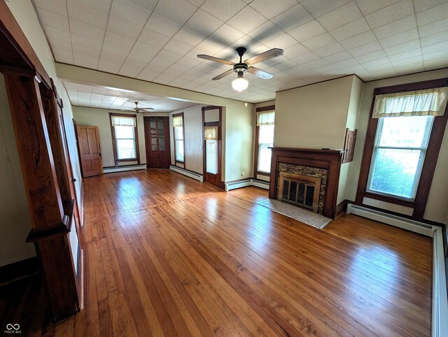 4335 River Rd, Columbus, IN 47203 - unfurnished living room featuring a ceiling fan, baseboard heating, and a stone fireplace