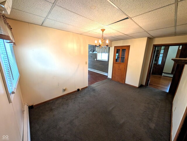 4335 River Rd, Columbus, IN 47203 - carpeted empty room with a chandelier, a paneled ceiling, baseboards, a baseboard radiator, and a baseboard heating unit