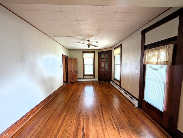 4335 River Rd, Columbus, IN 47203 - empty room with a baseboard heating unit, baseboard heating, hardwood / wood-style floors, a ceiling fan, and baseboards