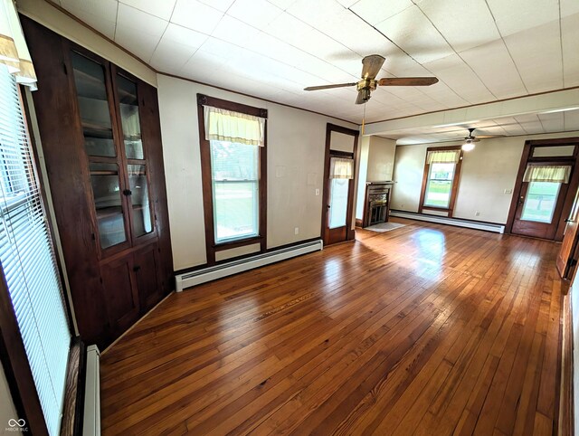 4335 River Rd, Columbus, IN 47203 - unfurnished living room with baseboard heating, a baseboard radiator, ceiling fan, hardwood / wood-style flooring, and a fireplace with raised hearth