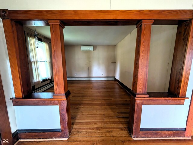 4335 River Rd, Columbus, IN 47203 - spare room featuring wood-type flooring, a wall mounted air conditioner, baseboards, and baseboard heating