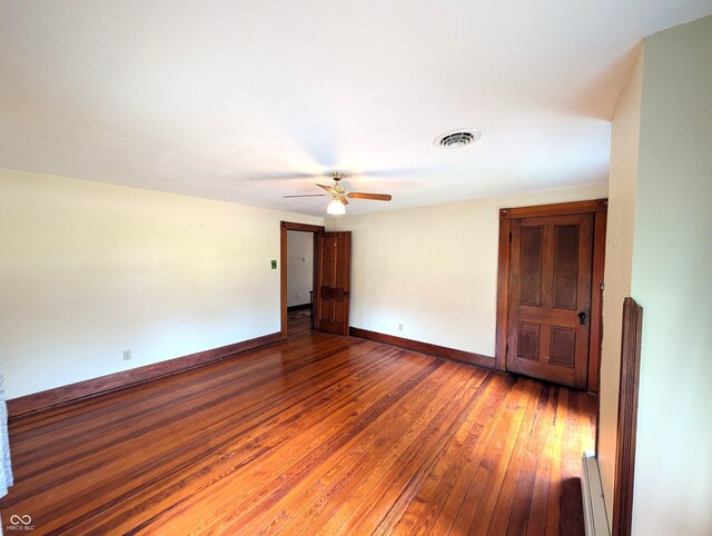 4335 River Rd, Columbus, IN 47203 - empty room featuring hardwood / wood-style flooring, baseboards, ceiling fan, and a baseboard heating unit