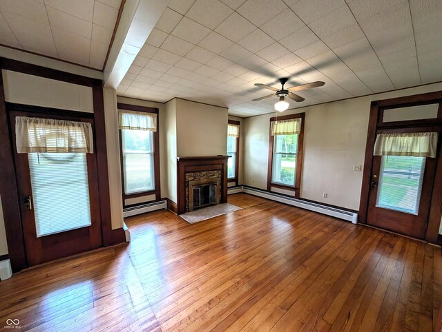 4335 River Rd, Columbus, IN 47203 - unfurnished living room with a baseboard radiator, hardwood / wood-style floors, and plenty of natural light