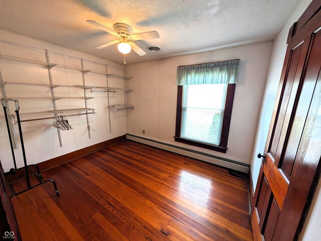 4335 River Rd, Columbus, IN 47203 - unfurnished room featuring a textured ceiling, baseboard heating, a ceiling fan, dark wood-style flooring, and baseboards