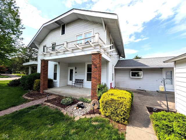 4335 River Rd, Columbus, IN 47203 - view of front of home with covered porch, a balcony, and a front lawn