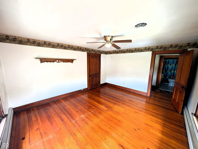 4335 River Rd, Columbus, IN 47203 - unfurnished room featuring baseboard heating, ceiling fan, baseboards, and dark wood-style floors
