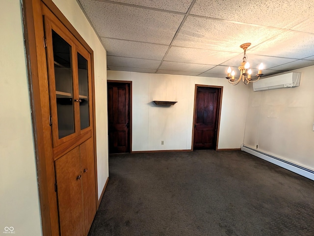 4335 River Rd, Columbus, IN 47203 - spare room with a wall mounted AC, a drop ceiling, baseboards, a chandelier, and dark colored carpet