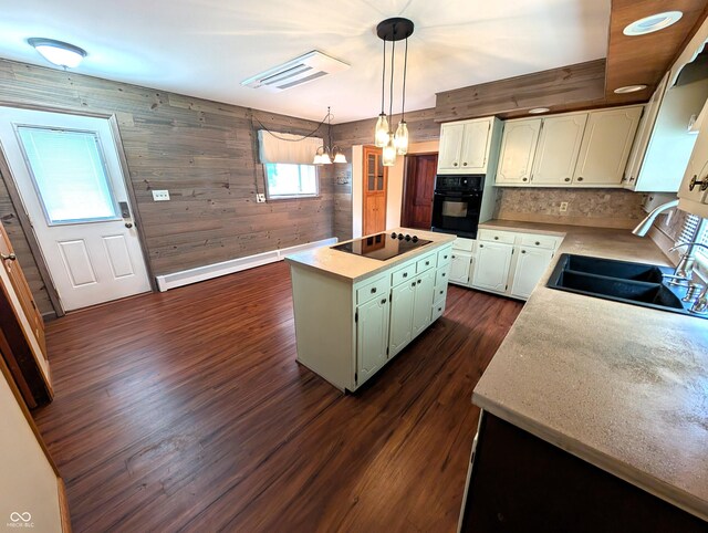4335 River Rd, Columbus, IN 47203 - kitchen featuring black appliances, a sink, a kitchen island, dark wood-style flooring, and wooden walls