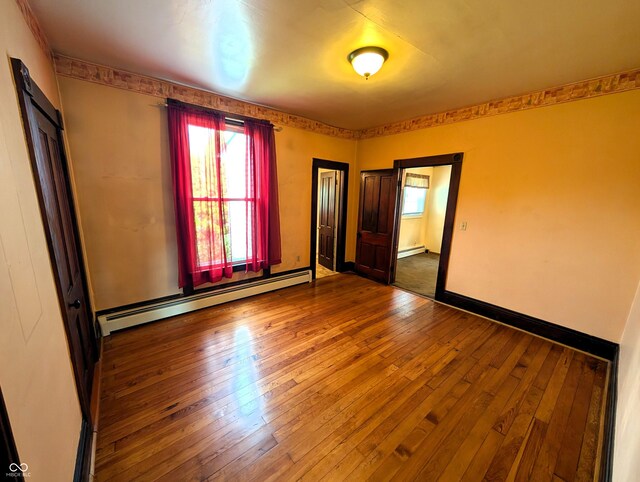 4335 River Rd, Columbus, IN 47203 - spare room featuring baseboard heating, hardwood / wood-style floors, a baseboard radiator, and baseboards