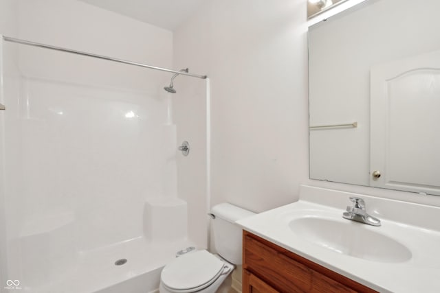 full bathroom with vanity, walk in shower, and toilet