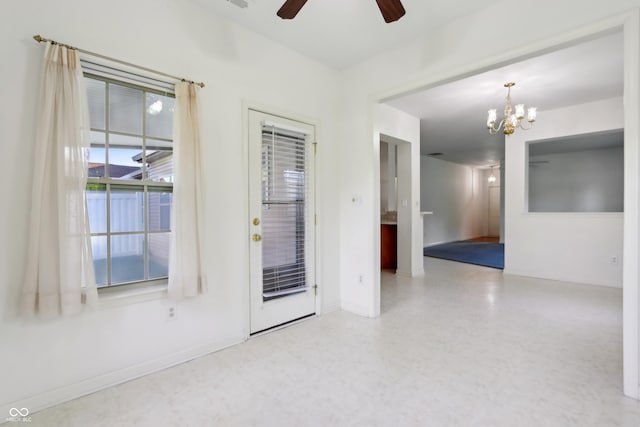 empty room featuring ceiling fan with notable chandelier