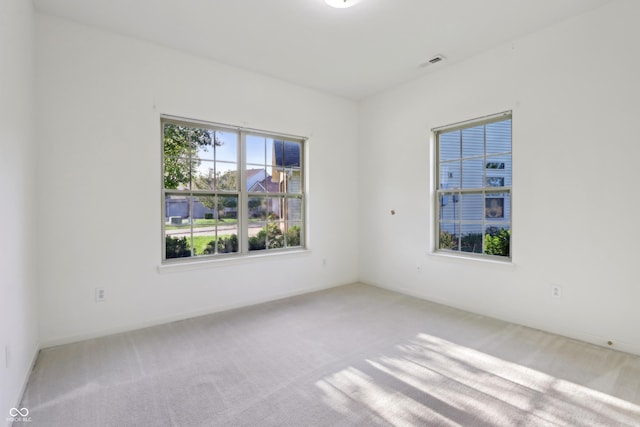 carpeted spare room with baseboards and visible vents