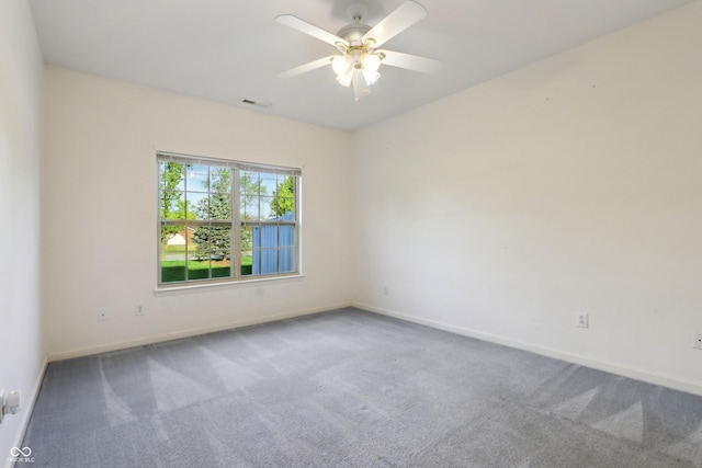 carpeted empty room featuring baseboards, a ceiling fan, and visible vents