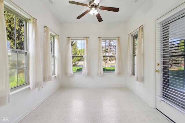 unfurnished sunroom featuring baseboards and tile patterned floors