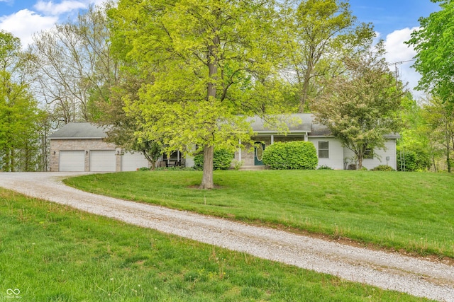 10154 S County Road 10 E, Cloverdale, IN 46120 - obstructed view of property featuring driveway, a front lawn, a garage, and stone siding