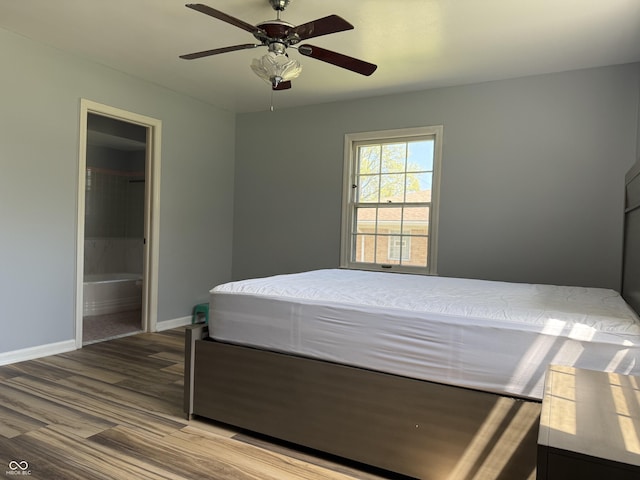 bedroom featuring wood finished floors, baseboards, connected bathroom, and ceiling fan