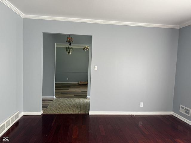 unfurnished room with ornamental molding, wood finished floors, and visible vents