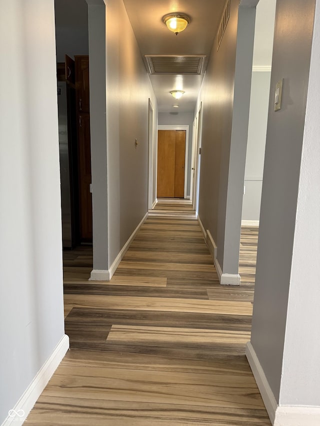 hall with baseboards and visible vents