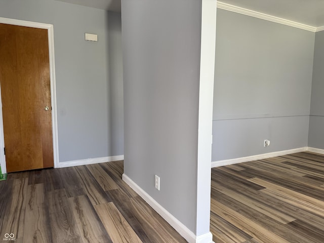 hallway with baseboards, ornamental molding, and wood finished floors