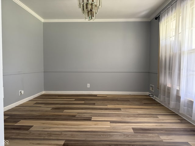 spare room featuring visible vents, baseboards, wood finished floors, and crown molding
