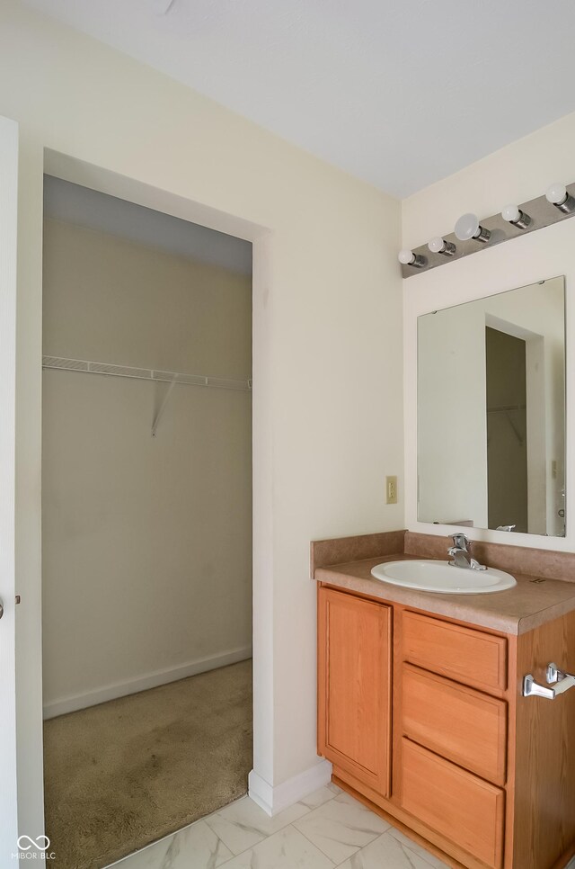 2138 Rossington Ln, Indianapolis, IN 46229 - bathroom with marble finish floors, vanity, baseboards, and a walk in closet