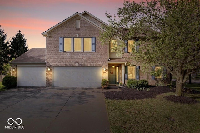 traditional-style home featuring a garage, a yard, driveway, and brick siding