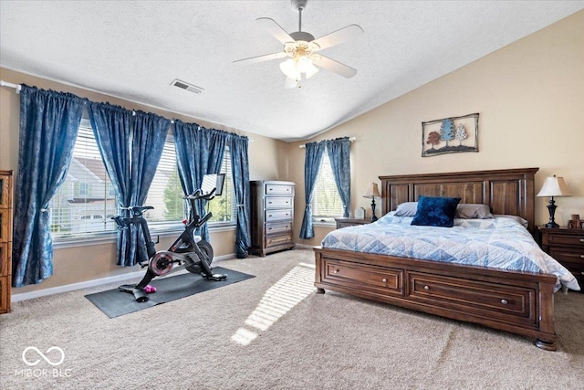 bedroom featuring a textured ceiling, visible vents, light carpet, and vaulted ceiling