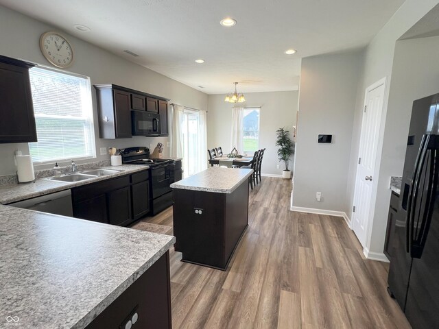 4245 W Fork Dr, Westfield, IN 46062 - kitchen featuring black appliances, a sink, a center island, light wood-style floors, and a chandelier