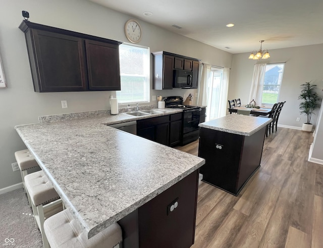4245 W Fork Dr, Westfield, IN 46062 - kitchen featuring black appliances, a sink, a chandelier, a center island, and light countertops