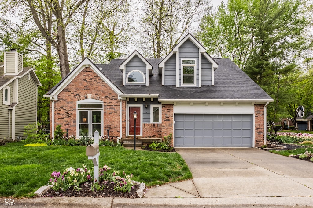 view of front of property featuring roof with shingles, driveway, a front lawn, and brick siding