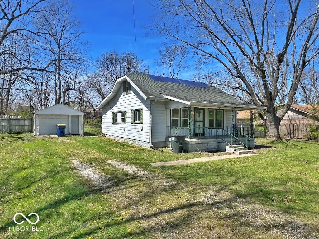 exterior space with an outbuilding, a porch, fence, a garage, and a yard