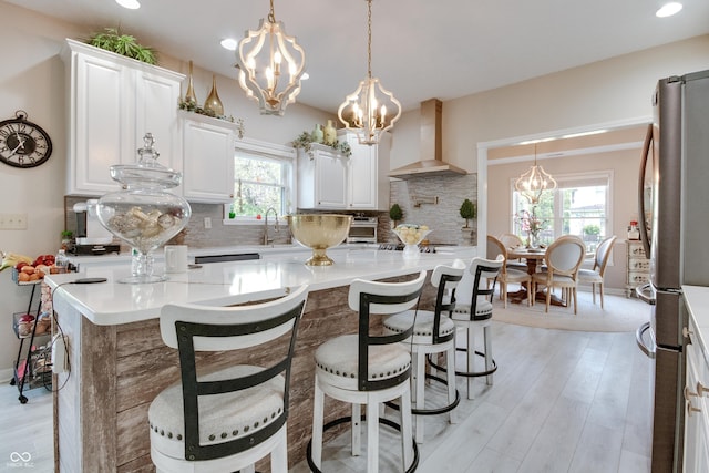 6054 Easy Ln, Indianapolis, IN 46259 - kitchen featuring wall chimney exhaust hood, a chandelier, freestanding refrigerator, healthy amount of natural light, and recessed lighting