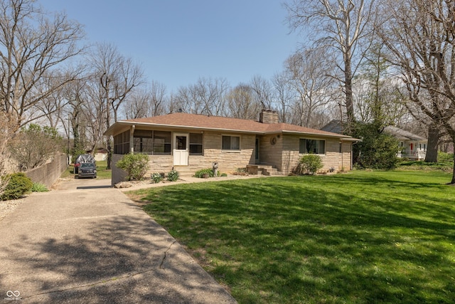 614 Debra Ln, Indianapolis, IN 46217 - ranch-style house with a front lawn, driveway, stone siding, a chimney, and a sunroom