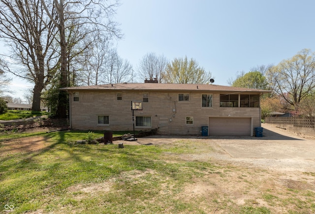 614 Debra Ln, Indianapolis, IN 46217 - back of property featuring a chimney, fence, concrete driveway, a lawn, and a garage