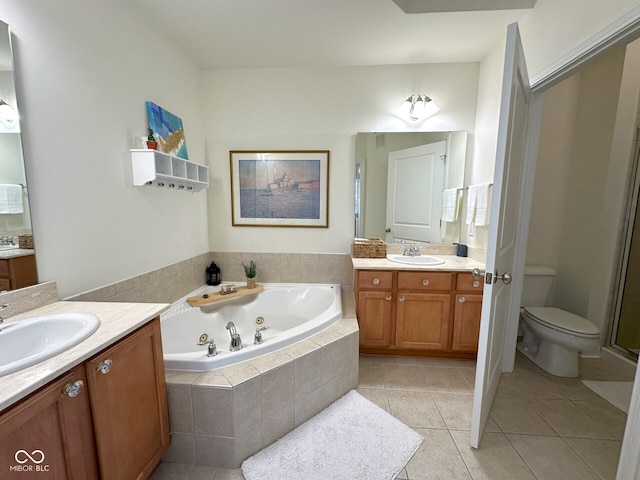 full bathroom featuring a tub with jets, two vanities, tile patterned flooring, and a sink