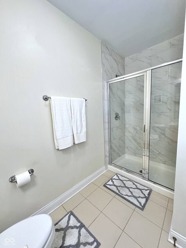 full bath with toilet, a shower stall, tile patterned flooring, and baseboards