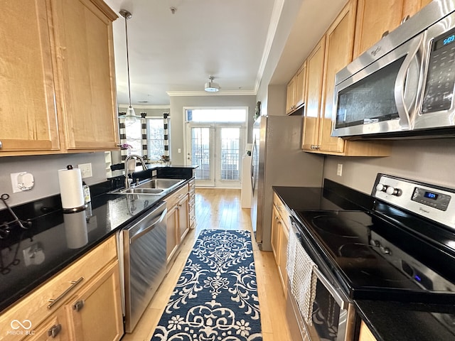kitchen with a sink, light brown cabinets, light wood-type flooring, crown molding, and appliances with stainless steel finishes