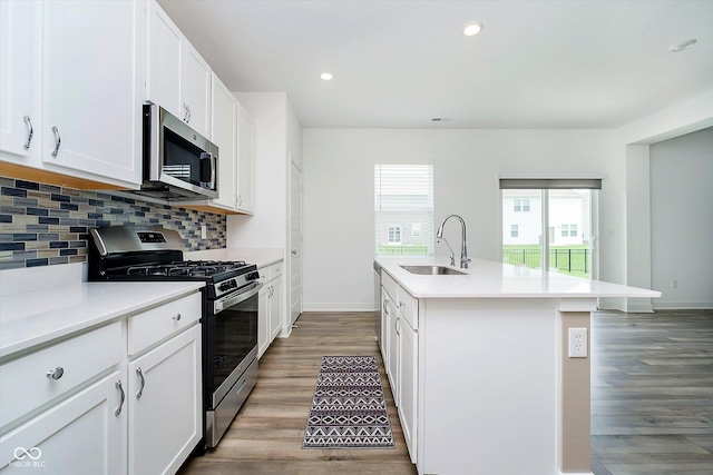 8654 Tripp Rd, Pendleton, IN 46064 - kitchen with stainless steel appliances, a sink, decorative backsplash, light countertops, and an island with sink