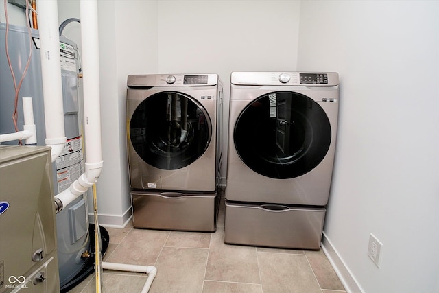 8654 Tripp Rd, Pendleton, IN 46064 - laundry room featuring washer and dryer, light tile patterned flooring, baseboards, and electric water heater