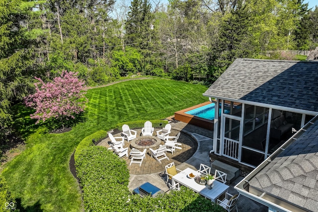 view of yard with an outdoor fire pit, a patio area, and a sunroom