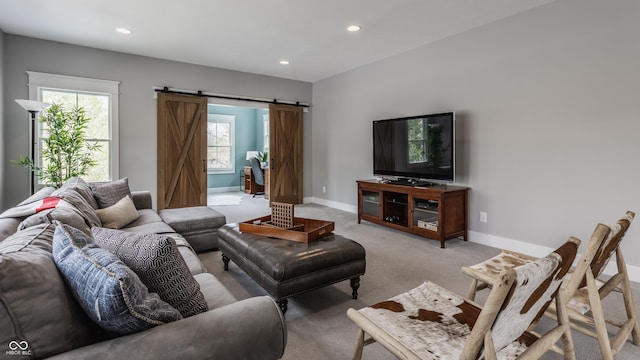 living area with a barn door, a healthy amount of sunlight, and recessed lighting