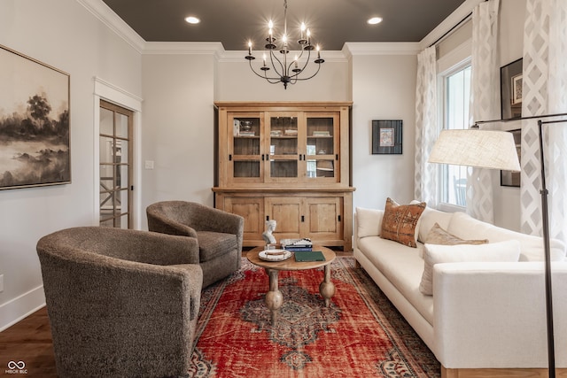 sitting room with recessed lighting, wood finished floors, an inviting chandelier, baseboards, and crown molding