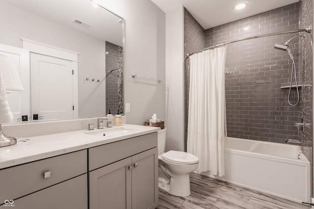 bathroom featuring shower / bath combo, vanity, toilet, visible vents, and wood finished floors