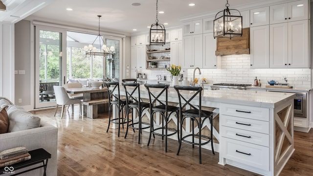 kitchen featuring white cabinets, a chandelier, and tasteful backsplash